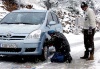 Conductores griegos colocan las cadenas en el coche que conducían por una carretera nacional en las inmediaciones de Nevrokopi, al norte del país, donde ha caído una intensa nevada.