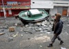 Un niño observa un bote  destruido por el  terremoto de 8,8 grados que sacudió en la madrugada del pasado sábado el centro y sur del país de Chile.