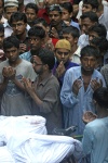 Lugareños y familiares rezan por las víctimas del incendio antes de su entierro en Nimtali, Dacca (Bangladesh.