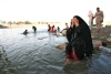 Una mujer iraquí vierte el agua sobre su cuerpo para refrescarse por el río Tigris en Bagdad, Irak. La Administración General de Supervisión Meteorológica y Sísmica informó que Las temperaturas alcanzarán los 50 grados centígrados en Bagdad.