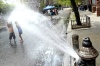 Niños juegan con el agua que escapa de un hidrante para refrescar el ambiente en el cuarto día de temperaturas record en la 101 Street en Harlem, Nueva York , EE.UU.