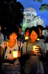 Un grupo de personas porta velas durante una ceremonia de recuerdo de las víctimas de la bomba atómica de Hiroshima.