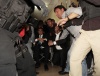 Miembros de la prensa nacional e internacional se protegen en el piso del fuego cruzado mientras militares sacan al presidente de Ecuador.