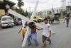 Un penitente filipinos carga con una cruz de madera por las calles de San Pedro Cutud.
