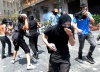 Jóvenes encapuchados usaron martillos para romper el pavimento y hacerse de piedras para arrojarlas contra la Policía. También incendiaron recipientes de basura en el centro de Atenas mientras la Policía los perseguía y les arrojaba gases.