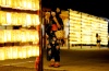 Una japonesa vestida con el tradicional kimono hace fotos de las miles de lamparillas encendidas durante el Festival de Mitama.