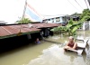 Una pareja espera la llegada de un equipo de rescate junto a su vivienda prácticamente sumergida en la provincia de Ayutthaya, Tailandia.