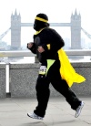 Un hombre vestido de gorila corre frente al Puente de Londres durante la carrera anual de gorilas.