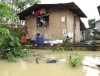 Filipinos se traslandan en bote por las calles de su comunidad que quedó rodeada de agua.