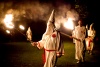 Miembros de la orden de los Caballeros de la Brigada Rebelde del Ku Klux Klan (KKK) encienden antorchas durante la ceremonia.