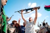 En Sirte, los jubilosos ex rebeldes festejaban la caída de la ciudad tras semanas de asedio sangriento, blandiendo fusiles, cuchillos y hasta alguna cuchilla de carnicero mientras entonaban el himno nacional.