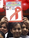 Una estudiante india sostiene una pancarta con un lazo rojo durante un evento para conmemorar el Día Mundial del Sida, en Jammu, India. EFE