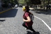 Una joven estudiante enmascarada corre durante una protesta estudiantil.