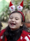 Una niña vestida de Santa Claussonríe tras su función de Navidad en una guardería en Katmandú, Nepal.