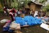 Varios residentes afectados por las inundaciones se distribuyen varias latas donadas.