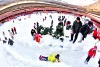 Niños no paran de jugar en un tobogan de nieve artificial en el estadio olímpico en Pekín.