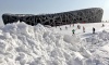 Niños no paran de jugar en un tobogan de nieve artificial en el estadio olímpico en Pekín.