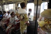 Las jóvenes japonesas vestidas con kimonos tradicionales, viajan en el vagón de un tren tras asistir a una de sus celebraciones.