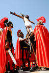 El nazareno muere y los soldados bajan el cuerpo lastimado de la cruz, mientras los asistentes rezan.