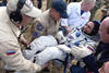 El astronauta ruso Anatoly Ivanishin es ayudado a salir del módulo de descenso de la nave rusa. (EFE)