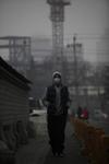 Un viandante utiliza una mascarilla mientras camina por una calle de Pekín (China). Los pekineses urgieron al gobierno a poner freno a la contaminación tras declararse ayer la alarma por la nube de contaminación que envuelve la ciudad.
