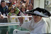 El papa respondió desde el papamóvil saludando a diestra y siniestra y haciendo un guiño desde el primer momento a la gente cubriéndose con un sombrero negro de charro con adornos plateados durante su visita a Guanajuato.