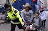 Un policía de Boston fue sacado del lugar en silla de ruedas con una herida sangrante en la pierna.