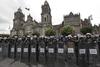 Cientos de policías se apostaron en las calles de acceso al Zócalo mientras esperaban la orden de entrar, al tiempo que los edificios de gobierno y los comercios de los alrededores fueron vaciados y cerraron sus puertas.