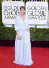 La actriz Amanda Peet con un holgado vestido blanco.