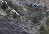 Miembros de los servicios de rescate colocan marcas rojas para realizar su trabajo entre fragmentos del avión esparcidos por un área de alta montaña.