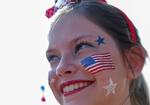Una chica festeja el Día de la independencia con maquillaje alusivo a la bandera de Estados Unidos.