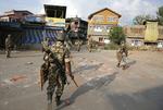 Soldados paramilitares indios caminan de regreso hacia su campamento durante el toque de queda en Srinagar, capital de la Cachemira india
