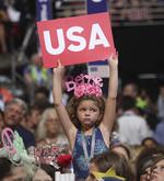 Una niña sostiene un cartel de Estados Unidos durante la convención.