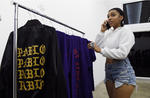 Josie Arias de Los Ángeles, habla por teléfono mientras inspecciona la ropa en la tienda pop-up de Kanye West.