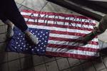 Manifestantes pisaron una bandera estadounidense con la palabra "Amerikka" escrita en ella ante el Ayuntamiento de Oakland.