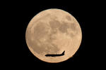 China. Un avión tiene como fondo la superluna, visto desde Beijing, China.