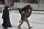 Soldado sirio que traslada a hombros a una mujer herida después de que el gobierno tomara el control de la zona en Alepo.