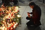 Un hombre enciende una vela en honor a las víctimas del atentado.