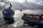 Imagen tomada por el fotógrafo británico Mathieu Willcocks que ha sido galardonada con el tercer premio en historias de "Noticias de Actualidad", en la que aparecen pescadores libios que lanzan chalecos salvavidas a inmigrantes que viajan a bordo de una patera en alta mar entre las costas de Libia e Italia.