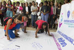 Mujeres escriben sus demandas en un gran cartel durante una manifestación en la Universidad Autónoma de Santo Domingo (UASD), en República Dominicana.