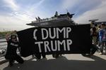 Manifestantes en zonas controladas cerca del Intrepid sostuvieron pancartas con leyendas de "Dump Trump" (Desháganse de Trump).