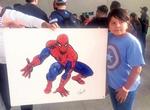 El niño Mateo muestra la firma del creador del Hombre Araña, Stan Lee, en un póster del súper héroe, obtenido en la inauguración de la convención.