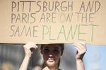Una manifestante sostiene una pancarta en la que se lee 'Pittburgh y París están en el mismo planeta', durante las protestas.