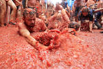 Los asistentes se arrojan toneladas de tomates maduros hasta terminar bañados en pulpa roja.
