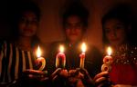 Varias chicas posan con velas encendidas durante las celebraciones de bienvenida del nuevo año, en Bhopal, India.