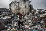 Fotógrafo: Kadir van Lohuizen, ganador del 1er premio de la categoría "Environment - Stories". Muestra a un hombre mientras carga un enorme lomo de botellas recogidas para su reciclaje en el vertedero de Olusosun en Lagos, Nigeria