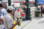 Al exterior comerciantes ofrecen flores frescas para llevar hasta la imagen de San Jorge.