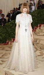 La actriz Dakota Fanning con un sencillo vestido color blanco con pequeñas piedras plateadas.