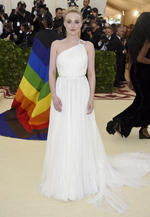 La actriz Dakota Fanning con un sencillo vestido color blanco con pequeñas piedras plateadas.