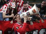 Jugadores del Atlético celebran después del juego con el trofeo en sus manos.